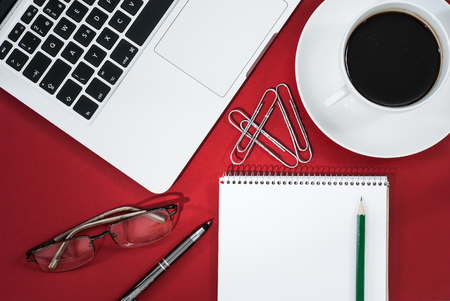 Business workspace concept. Top view. Red workspace concept with notebook and coffee.の写真素材
