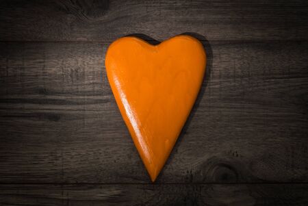 Valentines day celebration concept background. Orange hearth on wooden background table.の写真素材
