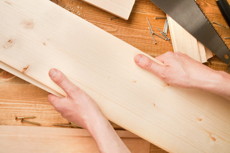 Man's hands holding two planks