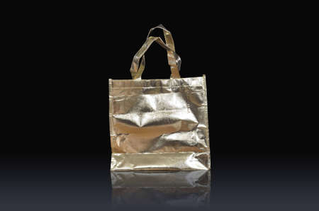 golden paper bag on reflect floor and black backgroundの写真素材