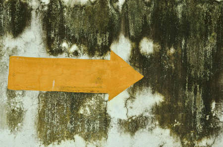 orange arrow shape painted old concrete wallの写真素材