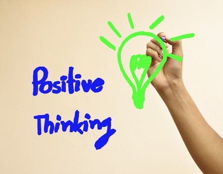 Male hand writing positive thinking and light bulbの写真素材