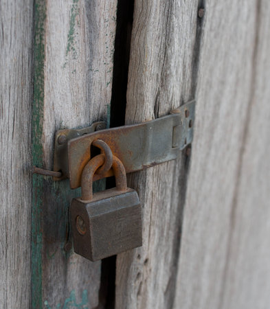 rusty padlock on old wooden door