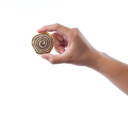 hand holding spiral cookie on white backgroundの写真素材