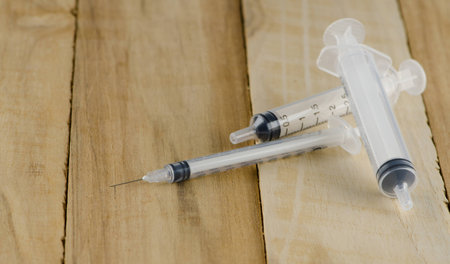 close up syringe on wooden tableの写真素材