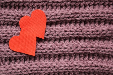 Two cotton hearts on a knitted violet background with copy spaceの写真素材