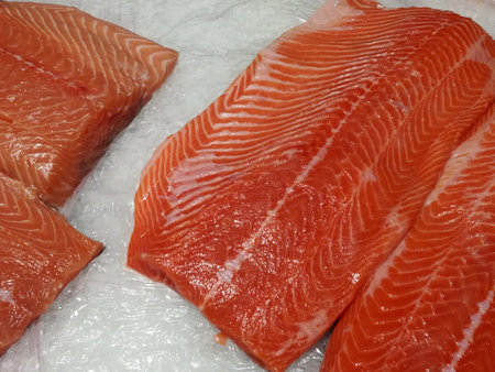 Fresh red fish salmon fillet close up on ice background.