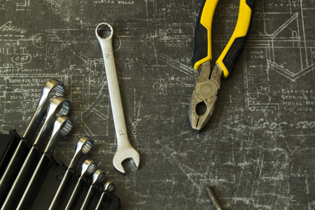 Tool set of pliers, different wrenches, bolts and nuts on abstract grey surfaceの写真素材