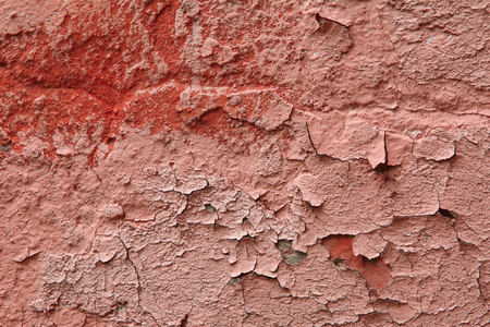 Close up fragment of an old exterior wall with cracked peeling plaster pink colorの写真素材