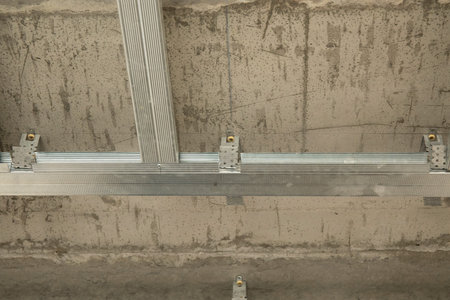 Drywall installation work in progress by construction workers at the construction site.