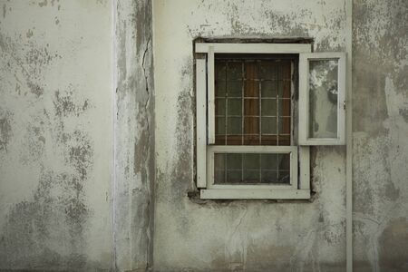 Old vintage weathered wall with wooden window with grillの写真素材