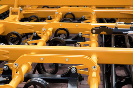Industrial springs on agricultural transportation and equipment element. Yellow metal