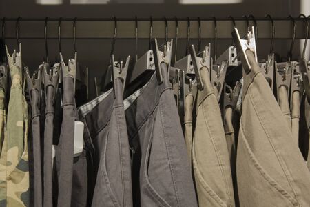 Many trousers hanging on a rack. Row of pants in closet. concept of buy , sell and shopping.の写真素材