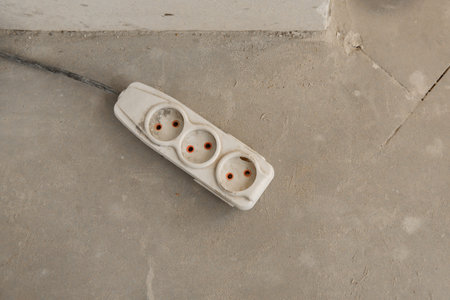 Extension socket plug on a concrete floor background