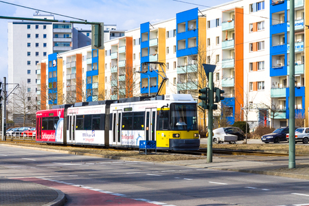 Modern yellow tram crossing the street in Berlin Hellersdorfのeditorial素材