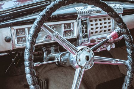 A vintage car cockpit with steering wheelの写真素材