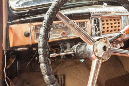 A vintage car cockpit with steering wheelの写真素材