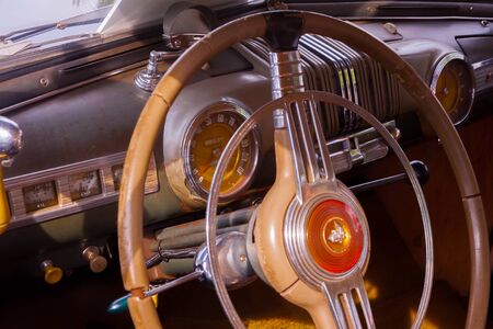 A vintage car cockpit with steering wheelの写真素材