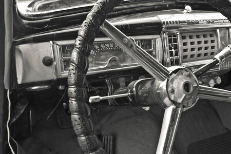 A vintage car cockpit with steering wheelの写真素材