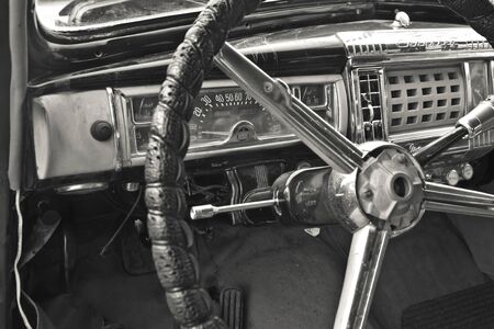 A vintage car cockpit with steering wheel