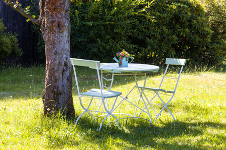 A table and two chairs in the sunny gardenの写真素材
