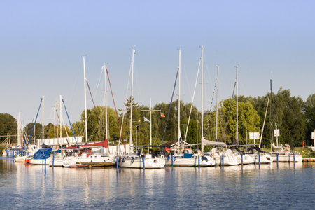 Yachts moored to a pier on a lake in summerの写真素材