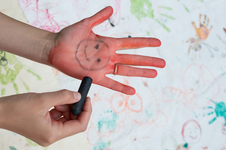 drawing a happy face on the palmの写真素材