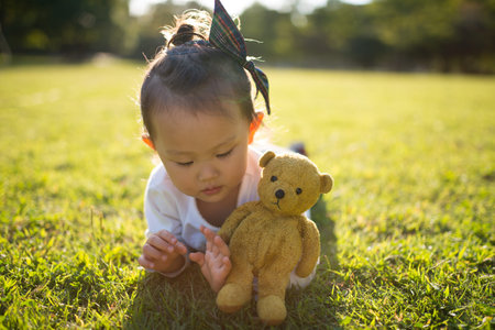 Cute Toddler playing with a teddy bearの写真素材