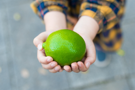 little girl holding a limeの写真素材