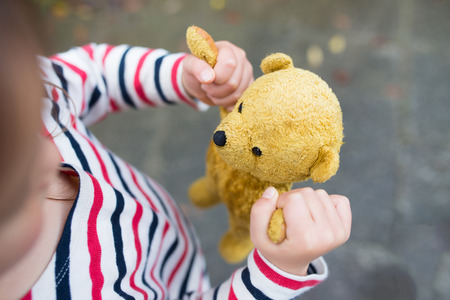 Girl playing with teddy bearの写真素材