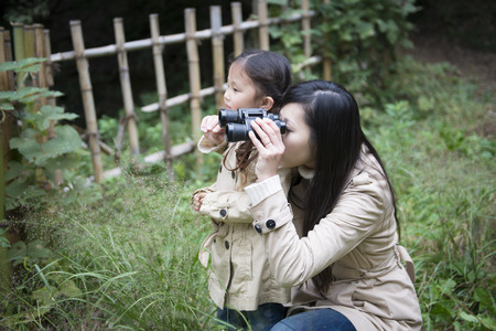 Mother and daughter seen with binocularsの写真素材