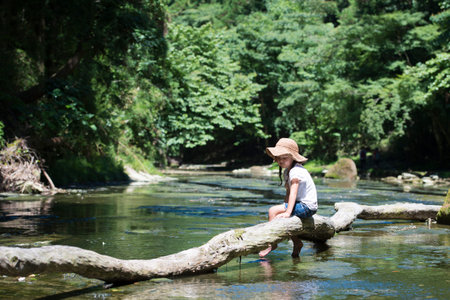 Happy little girl playing on a streamの写真素材