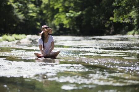 Beautiful woman relaxing in a mountain streamの写真素材