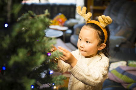 Little girl decorating Christmas treeの写真素材