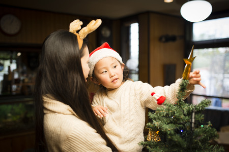 Mother and daughter decorating Christmas treeの写真素材