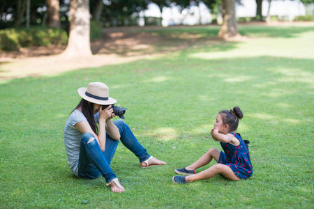 Mother taking a picture for her daughterの写真素材