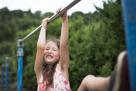 Little girl playing with an iron barの写真素材