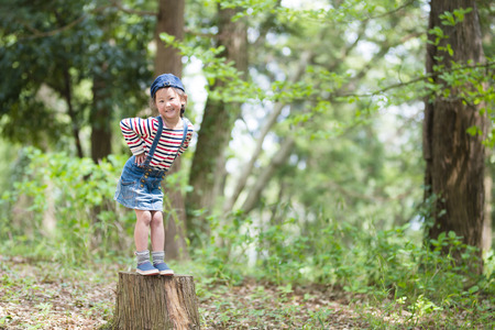 Little girl posing on a stumpの写真素材