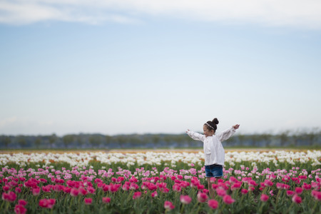 Little girl playing in a tulip fieldの写真素材