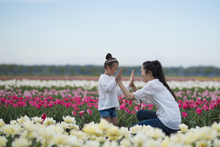Mother and daughter playing in the tulip fieldの写真素材
