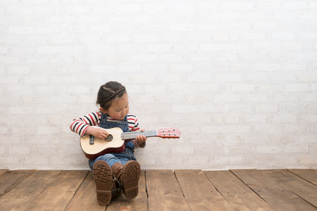 Little girl plays guitarの写真素材
