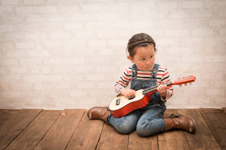Little girl plays guitarの写真素材