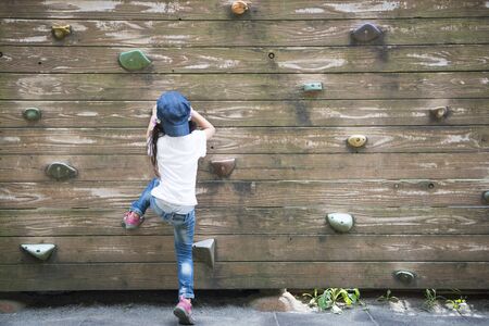 Little girl climbing the wallの写真素材