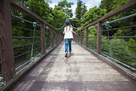 Little girl walking on the beidgeの写真素材