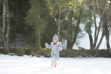 Happy little girl having fun on snowy dayの写真素材
