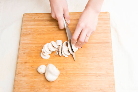Close up of hands cutting mushroomsの写真素材