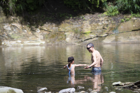 Father and daughter having fun in the riverの写真素材