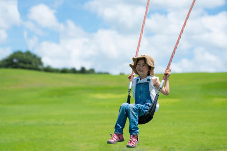 Happy little girl swinging in the beautiful scenery