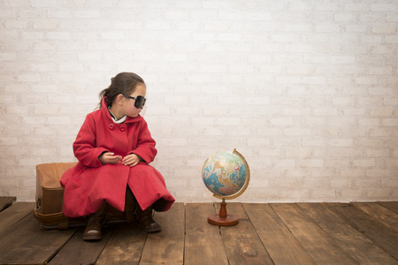 Concept travel, little girl at home dreaming of travelの写真素材
