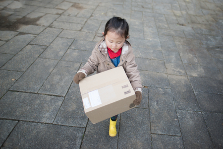 Little girl carrying a packageの写真素材